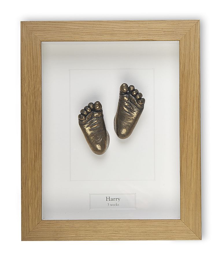 Tiny bronze resin baby feet set in an oak box frame