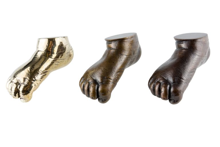 Three casts of the same foot but cast in different bronze finishes - highly polished, mid patina and traditional dark patina