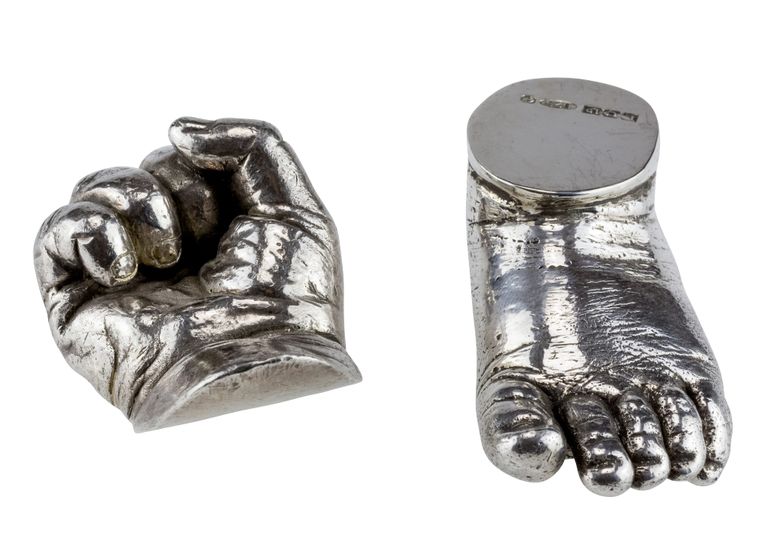 Sterling silver fist and top of foot with hallmark floating on a white background