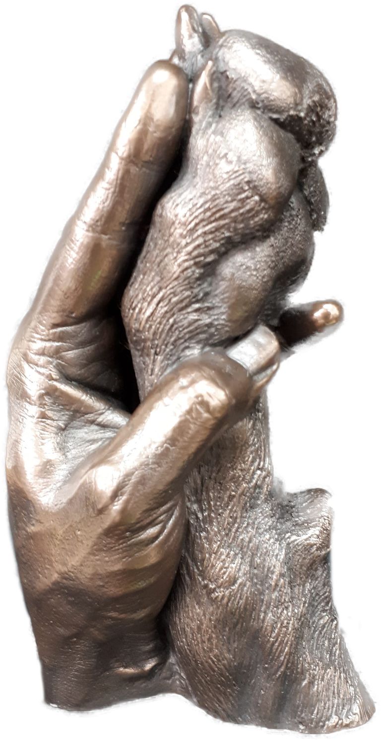 Bronze resin cast of owner holding her dog's paw which is almost as large as her hand