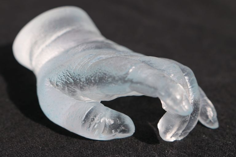Close up image of a glass baby hand cast, palm down
