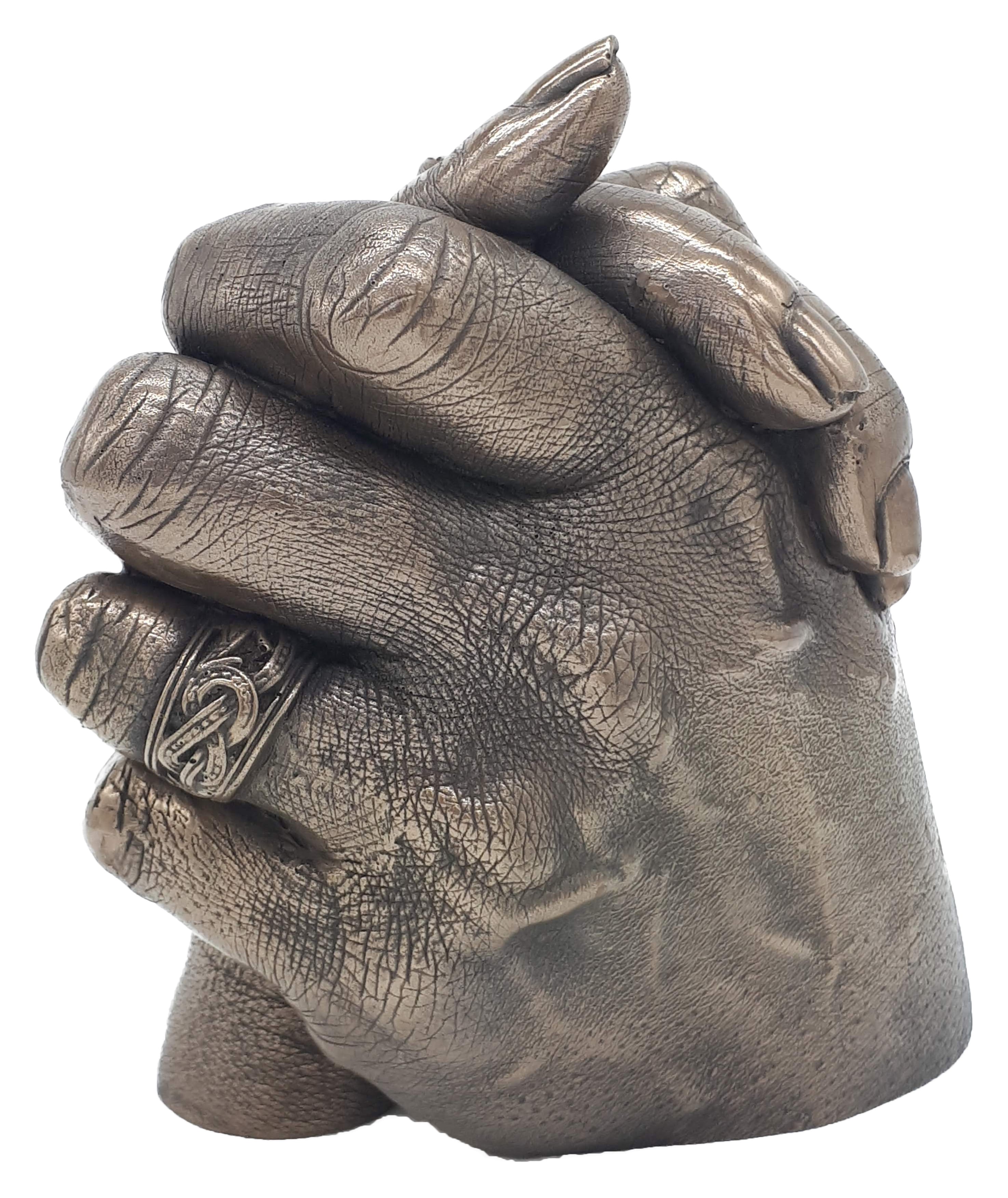 Stunning wedding band captured in a bronze cold cast of a couple holding hands