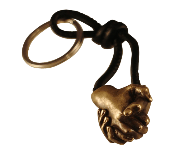 A miniature real bronze cast of two siblings holding hands made into a keyring